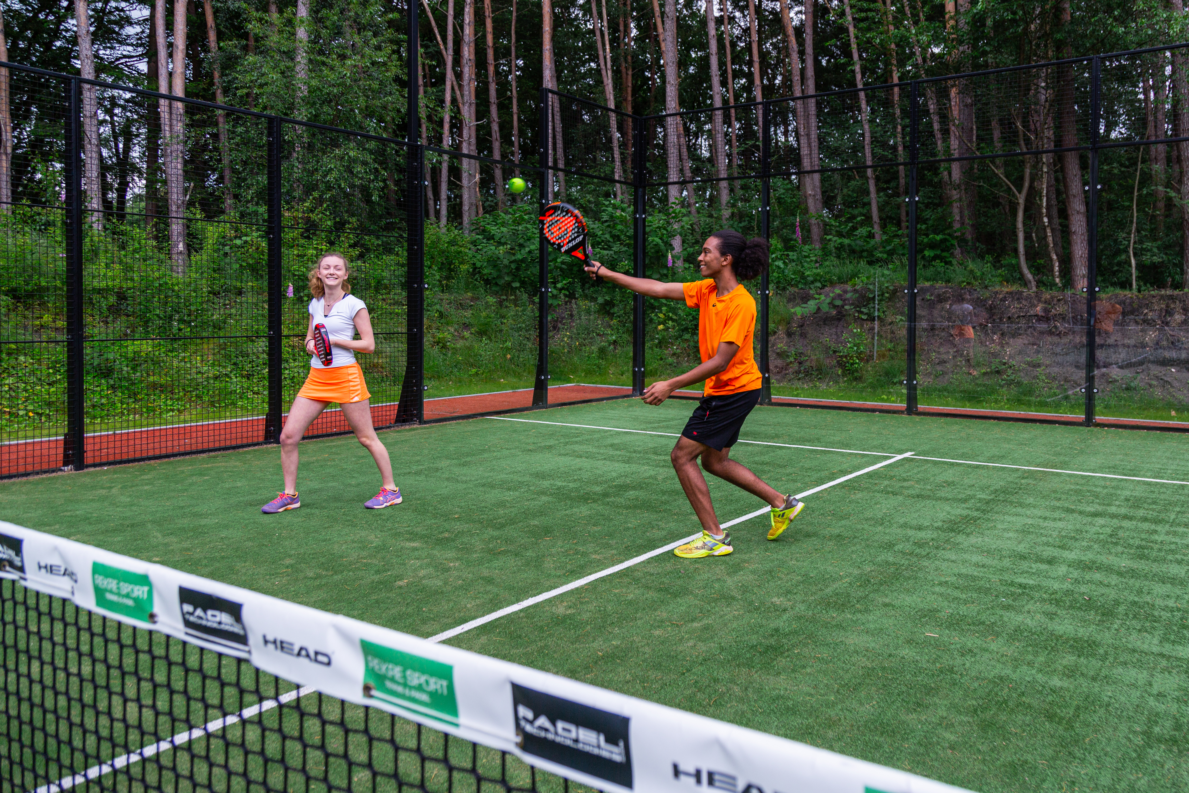 Meisje en jongen aan het padellen